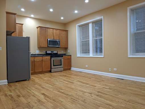 A kitchen with wooden floors and a refrigerator.