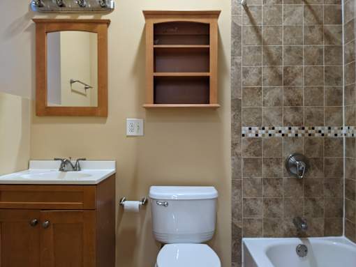 A bathroom with a toilet, sink, and shower.