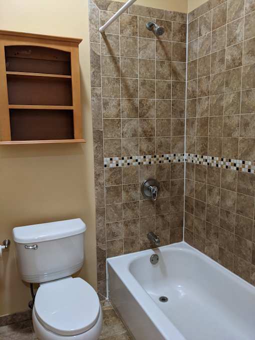 A white toilet sits next to a bathtub in a bathroom.