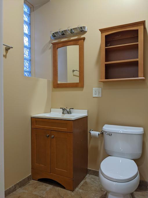 A white toilet sits next to a sink in a bathroom.