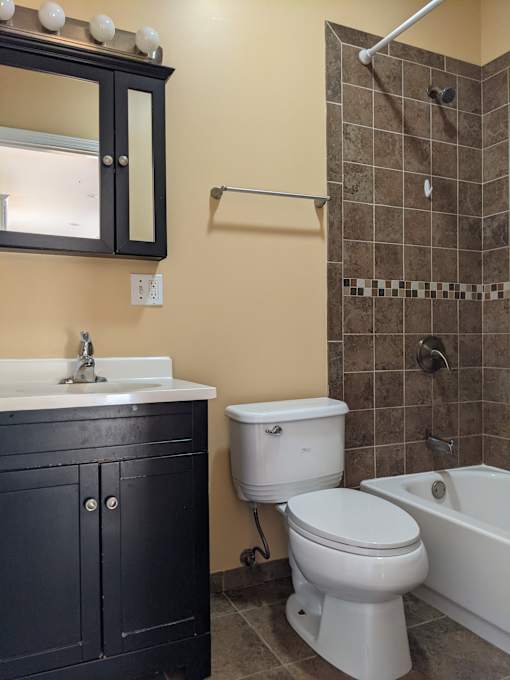 A white toilet sits next to a bathtub in a bathroom.