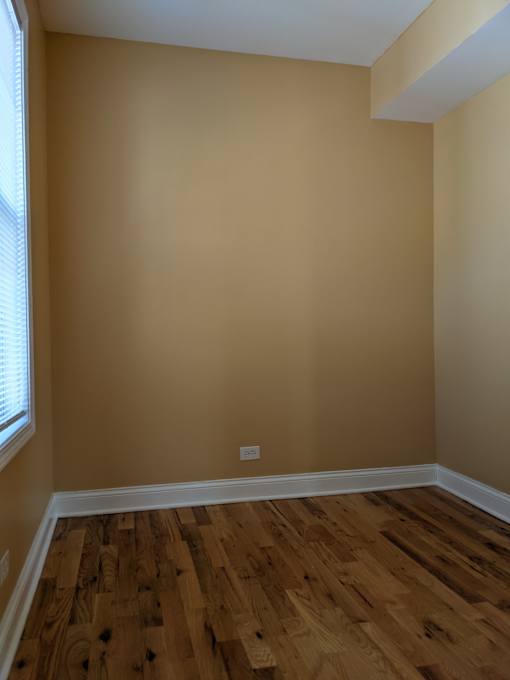 A room with wooden flooring and a window.