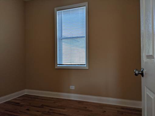 A room with a window and wooden floors.
