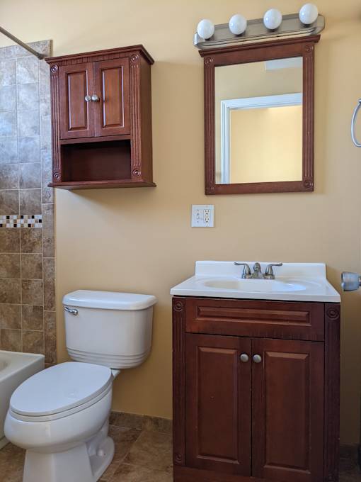 A white toilet sits next to a sink in a bathroom.