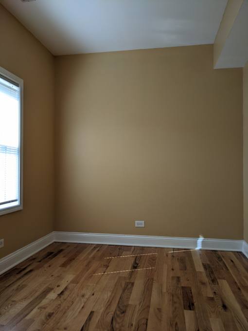 A room with wooden flooring and a window.
