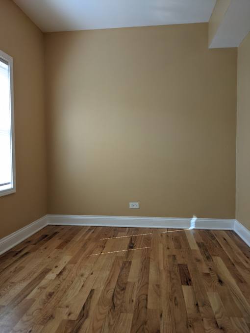 A room with wooden flooring and a window.