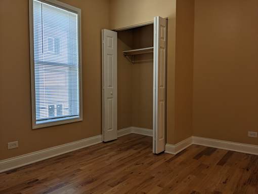 A room with a white door and a window with blinds.