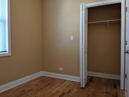 A room with a wooden floor and a white door.