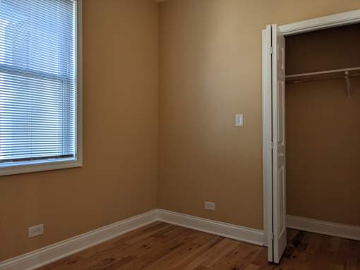 A room with a wooden floor and a white door.