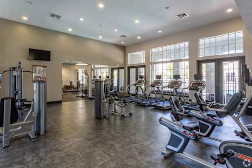 A gym with treadmills, elliptical machines, and other exercise equipment.