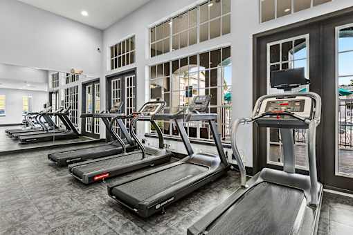 A gym with treadmills and elliptical machines.