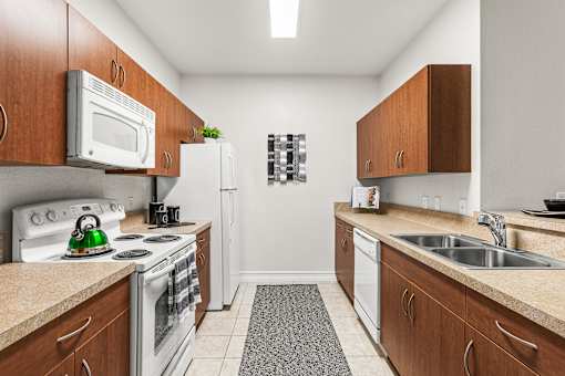 A kitchen with white appliances and wooden cabinets.