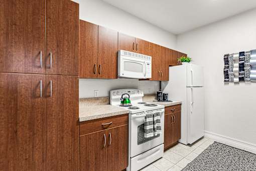 A kitchen with brown cabinets and white appliances.