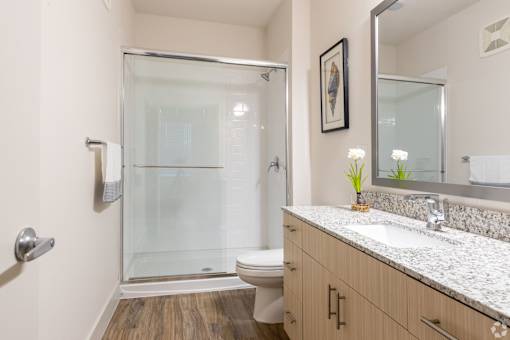 A bathroom with a toilet, sink, and shower.