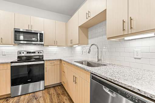 A kitchen with wooden cabinets and a granite countertop.