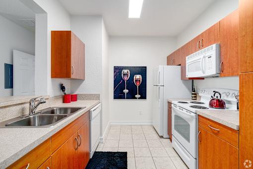 A kitchen with wooden cabinets and a fridge.