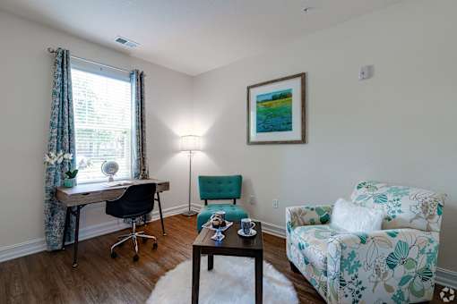 A room with a desk, chair, and couch.