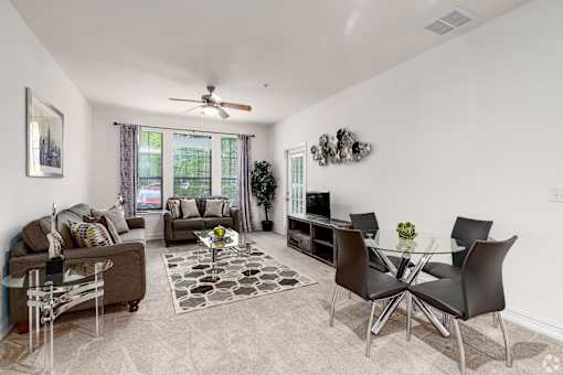 A living room with a glass table and chairs.