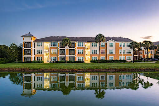 A large building with a reflection in the water in front of it.