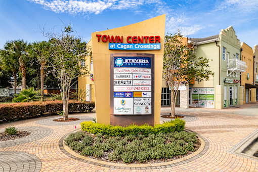 A sign for the Town Center at Cagan Crossings with a phone number and a list of businesses.