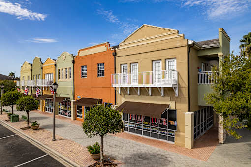 A street view of a row of colorful buildings with a clear blue sky above.