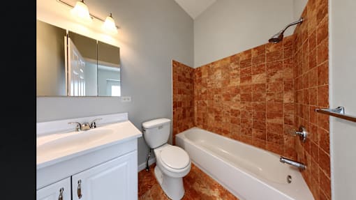 A bathroom with a toilet, sink, and bathtub.