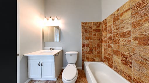 A bathroom with a toilet, sink, and tub.