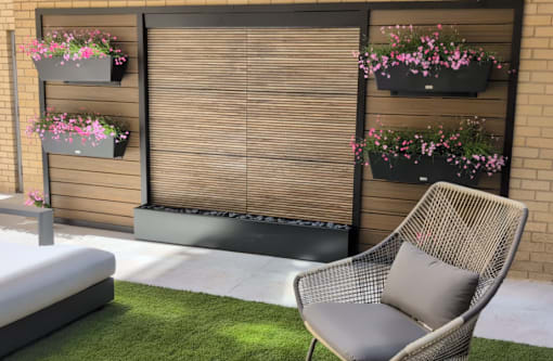 A patio with a chair, a bench, and flower pots.