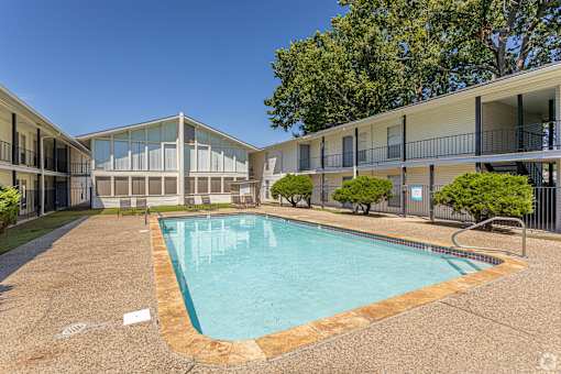 A swimming pool in a courtyard surrounded by apartment buildings.