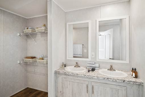 A bathroom with two sinks and a large mirror.