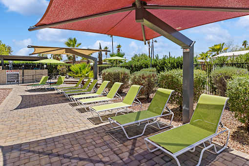 Poolside loungers with sun shades at Verde Plaza Manufactured Home Community in Tucson, Arizona