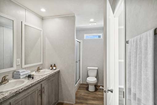 A bathroom with a toilet, sink, and mirror.