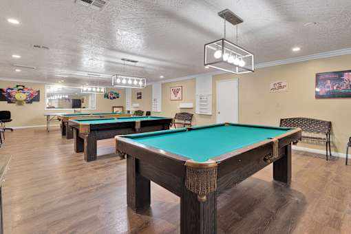 A pool table in a room with a light hanging from the ceiling.