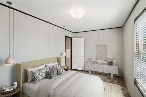 A bedroom with a large bed and a window with blinds.