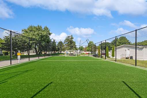 Tennis court with fence surrounding it at Candlelight Village Manufactured Home Community in Sauk, IL