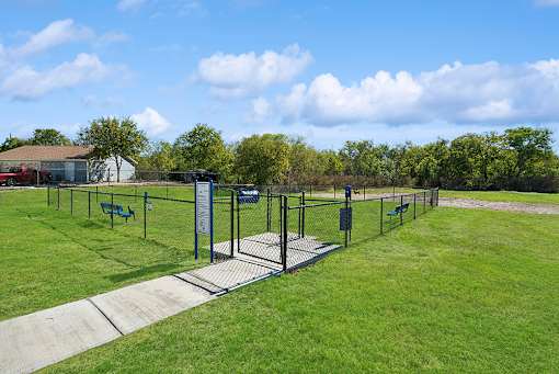 A park with a fence and benches.