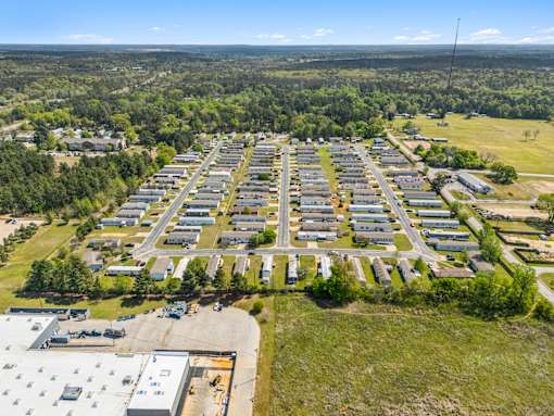 A large aerial view of a parking lot surrounded by buildings and trees.