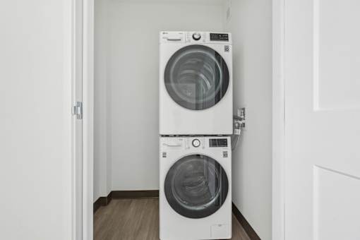 Two white front loading washing machines in a small room.