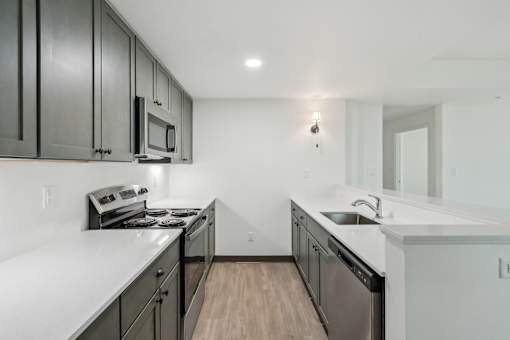 A kitchen with black cabinets and white countertops.