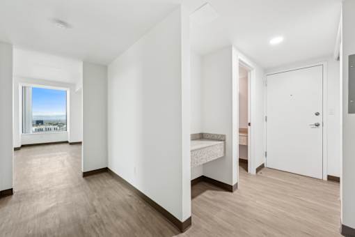 A room with a bed and a window overlooking a cityscape.