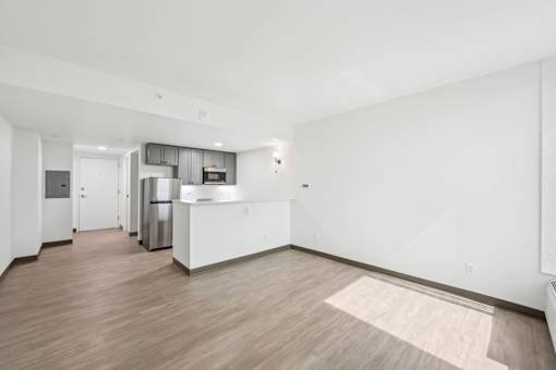 A kitchen with white cabinets and a wooden floor.