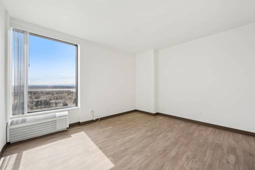 A room with a window overlooking a landscape.