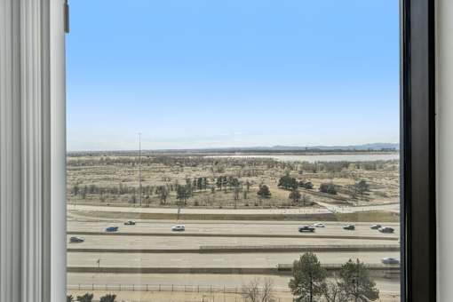 A view from a window looking out onto a highway with cars on it.