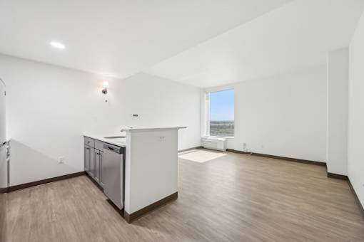 A kitchen with white cabinets and a wooden floor.