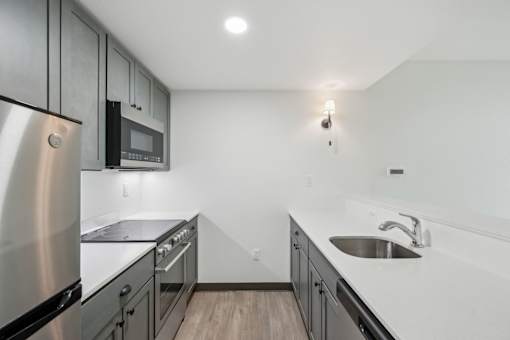 A modern kitchen with stainless steel appliances and a white countertop.