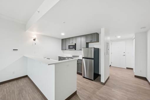 A modern kitchen with a white countertop and stainless steel appliances.