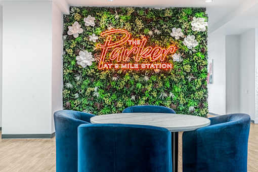 A green wall with flowers and the words "The Parker at Smile Station" written in neon.