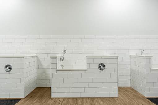 A white tiled bathroom with two sinks and a bathtub.
