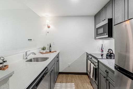 A modern kitchen with stainless steel appliances and a white countertop.