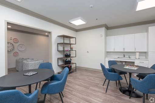 A dining room with a round table and blue chairs.
